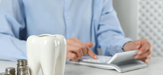 a woman calculating the cost of cosmetic dentistry