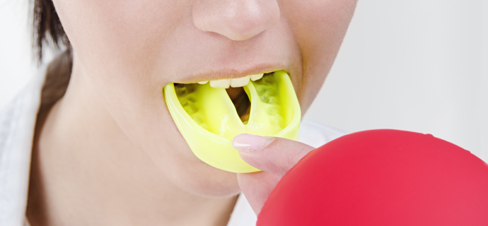 Woman placing athletic mouthguard