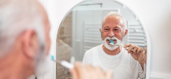 man brushing with dental implants in Indianapolis