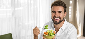 man eating healthy foods with dental implants in Indianapolis