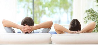 Couple relaxing at home on sofa
