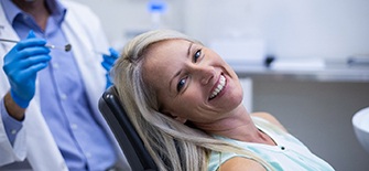 Woman in dental chair smiling after full mouth reconstruction in Indianapolis, IN