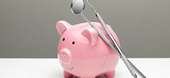 Piggy bank with dental instruments resting on it