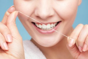 woman smiling holding floss