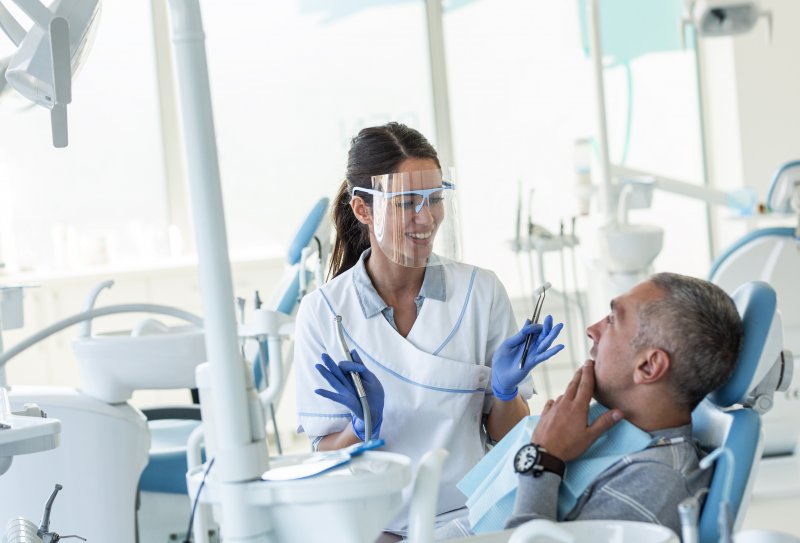 Dentist teaching patient how to maintain their dental bridge’s lifespan.