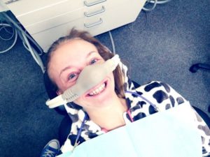 Smiling patient wearing nasal mask for nitrous oxide